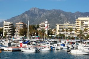 white-and-blue-boat-on-sea-near-city-buildings-during-daytime